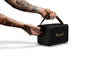 Person holding the Marshall speaker in both hands 