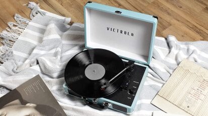 Blue record player on floor with blanket