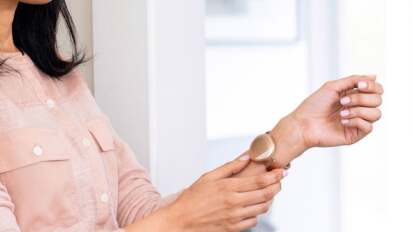 Person's arms wearing rose gold wearable