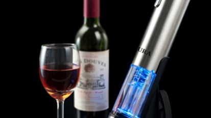 bottle and glass of wine next to blue and silver bottle opener