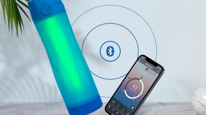 Blue water bottle with green center next to phone with bluetooth symbol