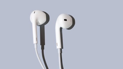 Wired earphones from Apple laying on a slightly gray surface