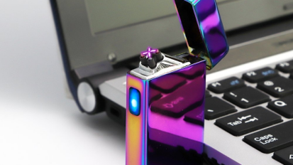 purple metallic lighter next to laptop