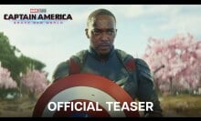 Sam Wilson holds the Captain America shield while standing in front of a group of cherry blossom trees.