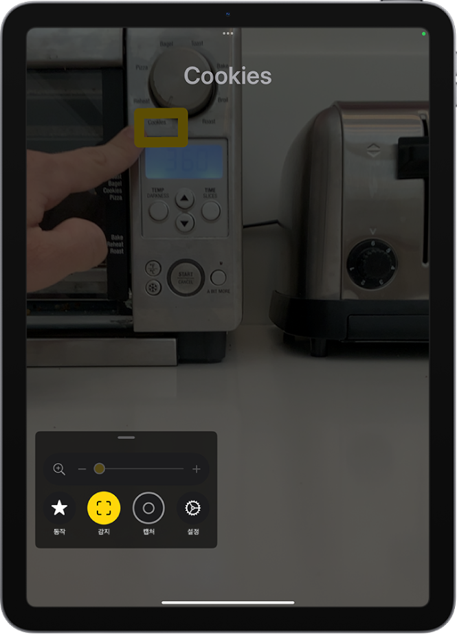 주방용품의 텍스트를 가리키고 있는 손가락을 감지한 확대기 앱.