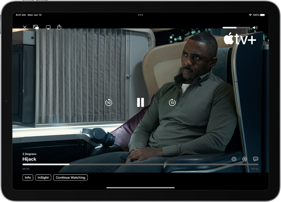 Um programa de TV a ser reproduzido, com os controlos visíveis. Os botões “Fechar”, “Picture-in-picture”, “AirPlay” e “Partilhar” estão na parte superior esquerda. O nivelador de volume está na parte superior direita. Ao centro, existem botões para retroceder 10 segundos, pausar e avançar 10 segundos. Em baixo, ao centro, existe um nivelador que pode ser arrastado para ajustar a posição do vídeo; o tempo decorrido e o tempo que falta aparecem de cada um dos lados do nivelador. Na parte inferior direita estão os botões “Informação”, “Em cena” e “Continuar a ver”.