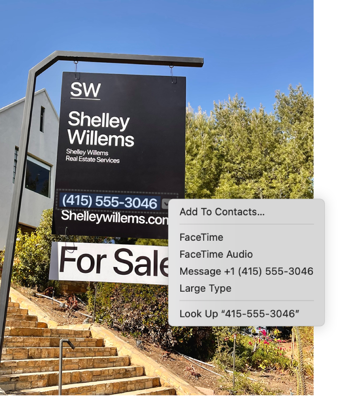 A photo of a real estate For Sale sign showing the agent’s phone number selected as Live Text and a menu presenting options to add the phone number to Contacts, call the number, start a FaceTime call, send a text message and more.