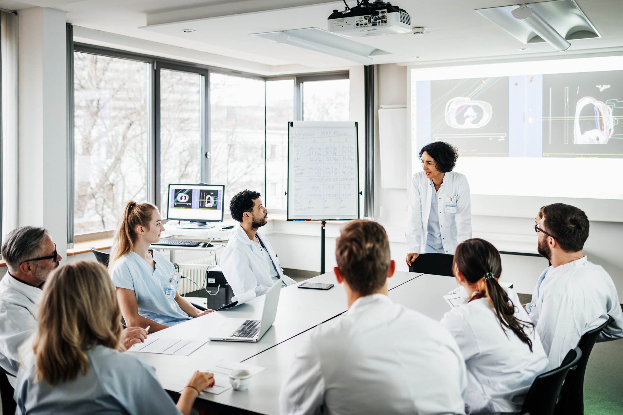 A group of doctors listening to a research presentation in hospital