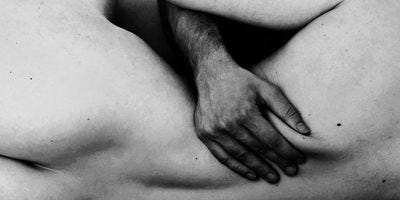 black and white photo of couple cuddling naked