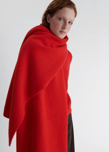 a model wearing a vibrant red shawl showcasing a minimalist design