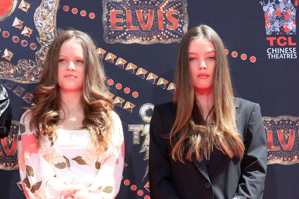 finley and harper lockwood pose for a photo in front of an elvis movie backdrop