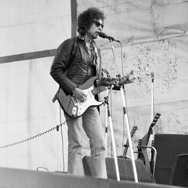 musician performing on stage with an electric guitar