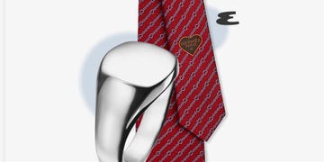 a silver ring and a red patterned tie with a heart design