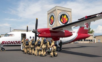 a group of soldiers standing next to a plane