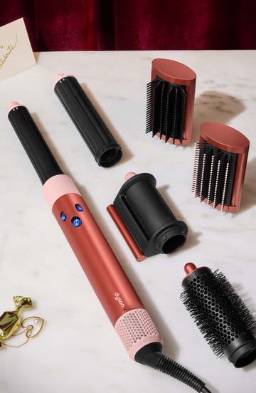 beauty styling tools including a hair styling device and various attachments on a marble surface