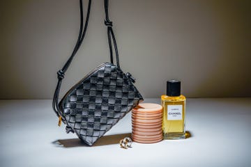 stylish handbag stacked beauty containers and perfume bottle