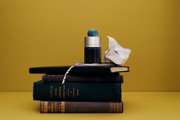 a bottle of fragrance on top of a stack of books