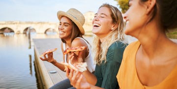 a group of women eating pizza