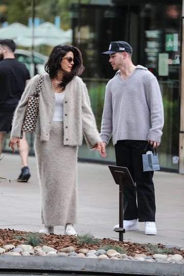 a couple holding hands while walking outdoors