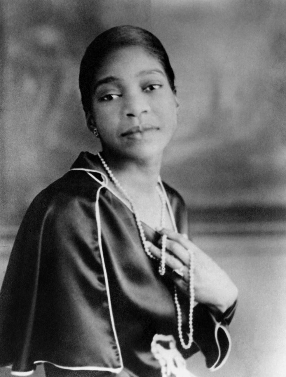 bessie smith holding pearls around her neck as she turns for a portrait photo