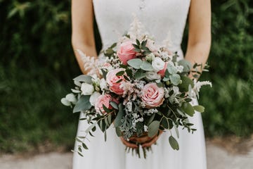 bride holding her bridal bouquet with pink roses and eucalyptus