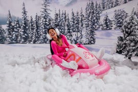 a person sitting on a pink snowmobile in the snow