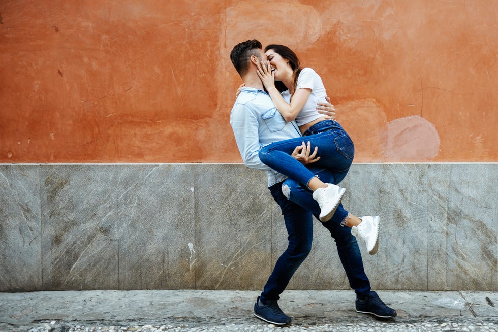 carefree couple in love in front of a wall outdoors