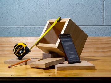 a tape measure spread across a wooden box with a phone displaying the chatgpt dashboard