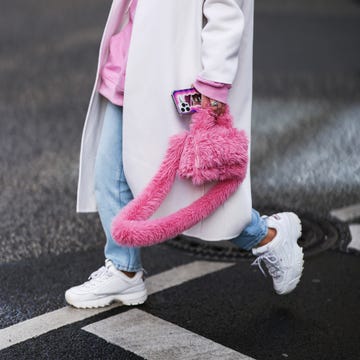 a person wearing a pink jacket and white shoes