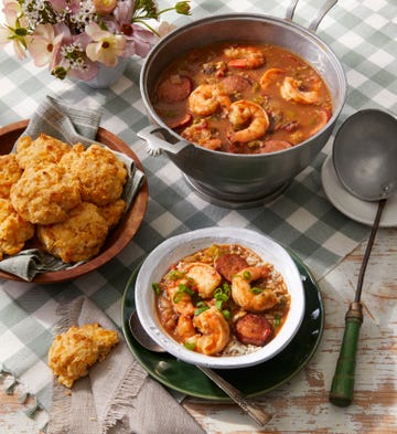 shrimp gumbo in a pot and bowl served with a side of drop biscuits