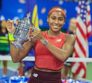 coco gauff holding up her trophy and smiling at the us open