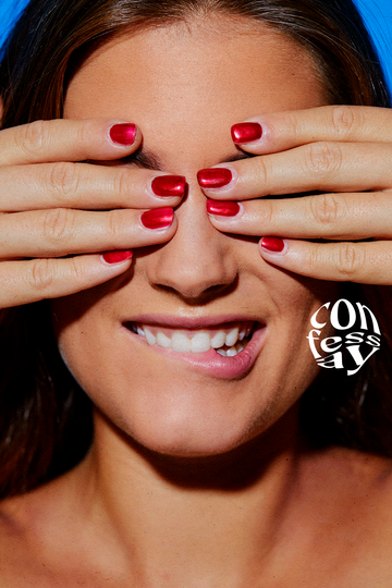 a woman with red fingernails covering her eyes and biting her lip