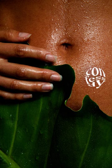 close up of a woman holding a green leaf against her stomach