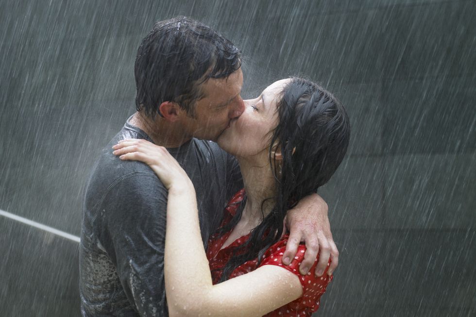 couple kissing in rain, side view, close up