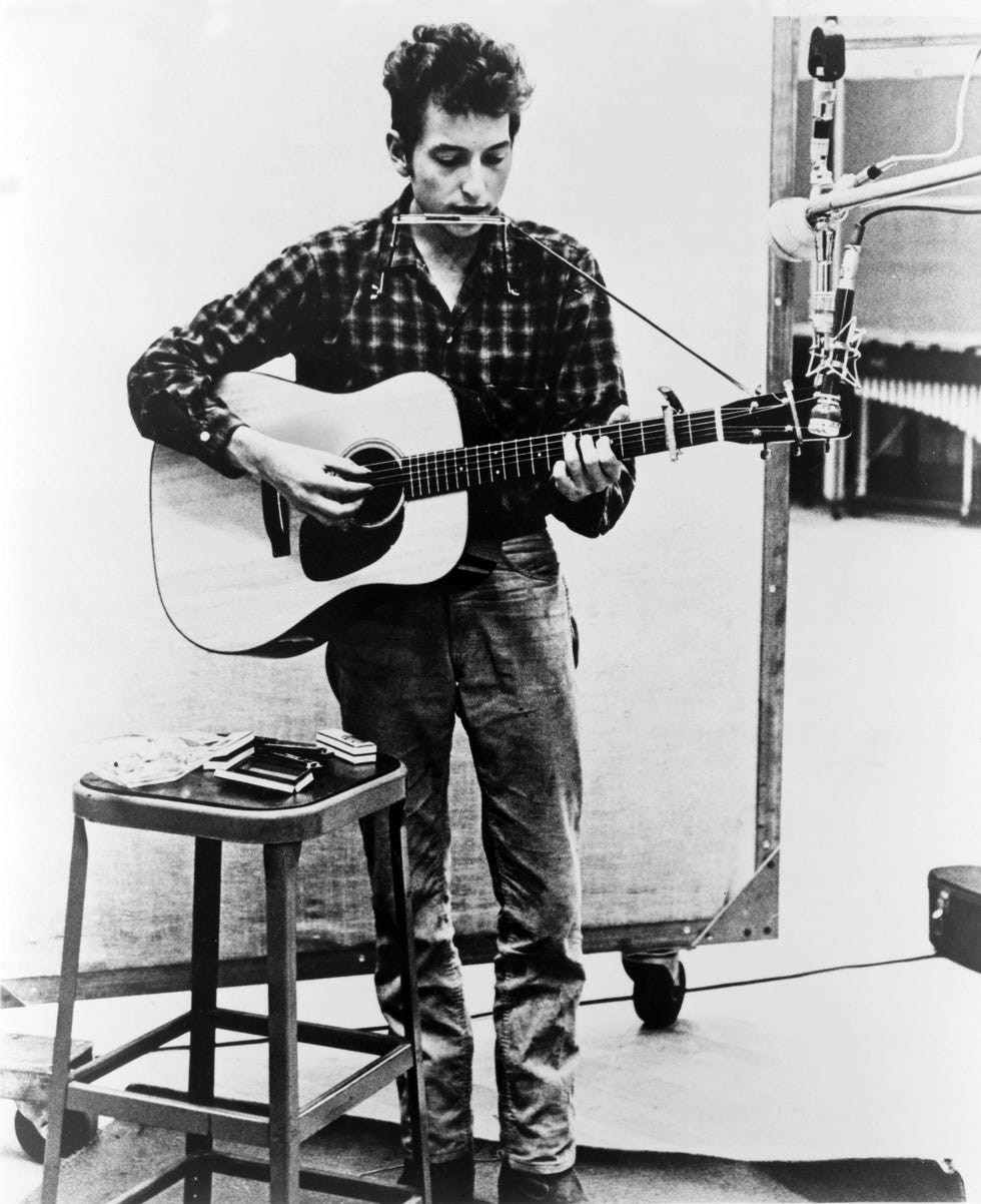 musician playing acoustic guitar in a recording studio