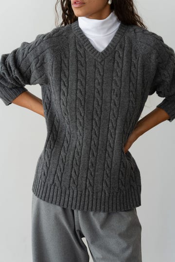 woman wearing gray cable knit v neck sweater