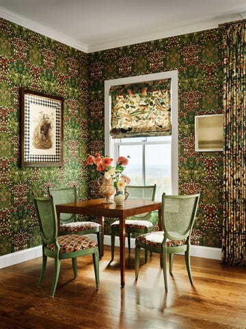 dining area featuring a table chairs floral arrangement and decorative wall elements