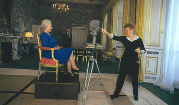 a woman standing next to an old man sitting in a chair