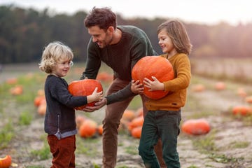 father and sons in pumpkin patch field fall activities