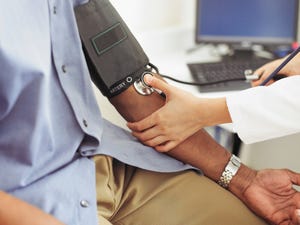 female doctor taking patient's blood pressure