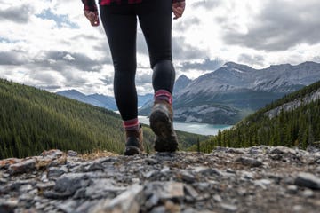 female hiker ascends mountain trail