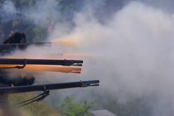 flintlock muzzle loader muskets guns firing smoke from the gunpowder fills the air