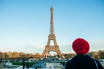 france, paris, view to eiffel tower with back view of young woman standing in the foreground