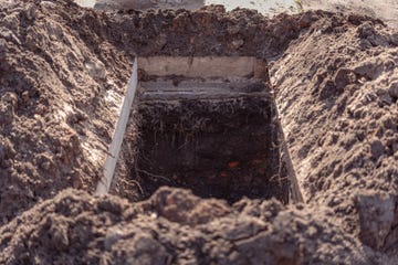 freshly dug grave pit at cemetery, a close up