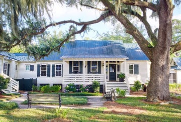 white coastal cottage with dark green shutters