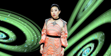 awkwafina in an orange dress surrounded by green swirls