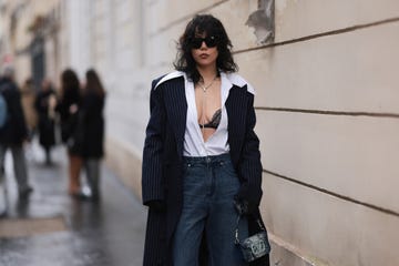 paris, france january 22 xiayan guo seen wearing denim dark blue jeans, valentino jeans shimmery bag, striped navy long coat, white blouse, black laced bra and black sunglasses outside georges hobeika during the haute couture springsummer 2024 as part of paris fashion week on january 22, 2024 in paris, france photo by jeremy moellergetty images