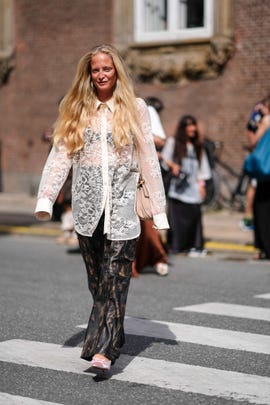 copenhagen, denmark august 08 a guest wears a white sheer mesh oversized shirt with floral embroidery, flared flowing pants, during day four of the copenhagen fashion week cphfw ss25 on august 08, 2024 in copenhagen, denmark photo by edward berthelotgetty images