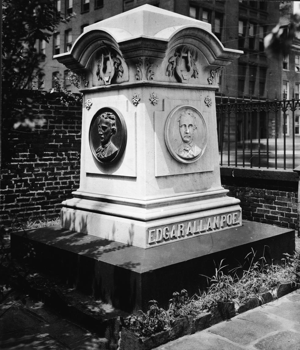 a large headstone engraved with edgar allan poe and busts of the man