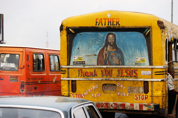 a painting of jesus and the message "thank you jesus" on the back of a bus in oshodi market in lagos